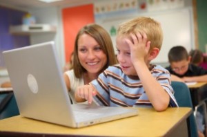 teacher working with student on laptop